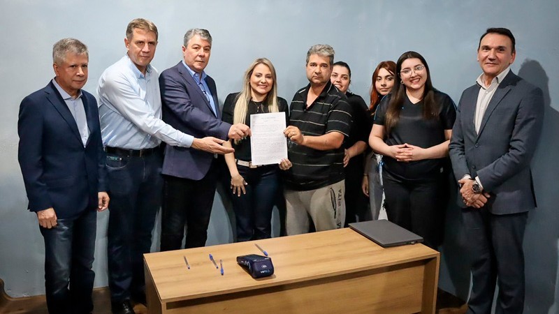 O primeiro contrato foi assinado por Belmiro Prado, na presença da sua família, autoridades do governo e diretoria do Banrisul