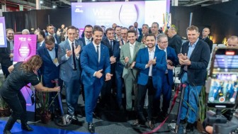 Grupo de homens aplaudem ao descerrar faixa de abertura do evento