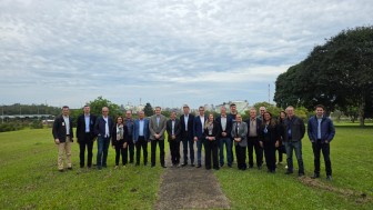 Foto de um grupo de pessoas, de pé, em um gramado