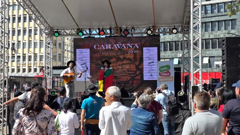 M&uacute;sicos se Apresentam num palco externo com p&uacute;blico assistindo