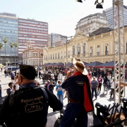 Músicos se apresentam em palco externo com público ao fundo