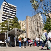 Público passante na rua, ao fundo palco externo